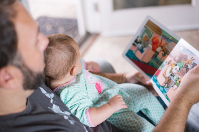 Отец с ребенком читают книгу. Фото иллюстрационное. Фото: Picsea, unsplash.com