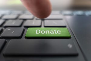 Донаты в BYSOL - уголовное дело за донаты. Red donate button on the keyboard close-up. blurred in motion background.