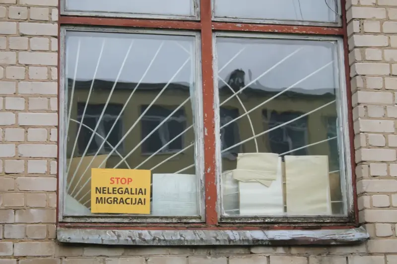 Акно на першым паверсе будынка, дзе першапачаткова планавалі абсталяваць лагер для бежанцаў. Надпіс на налепцы: «Стоп нелегальнай міграцыі». Фота: Hrodna.life